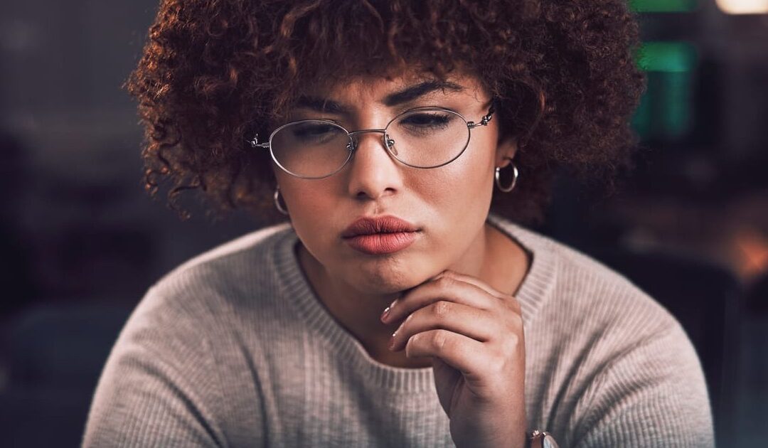 women in glasees in the office concentrated on something