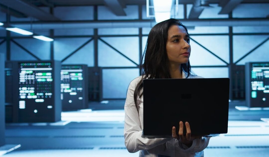 it professional in spacious room holding a laptop in her hands